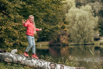 Fototapeta na wymiar child walking on log in park