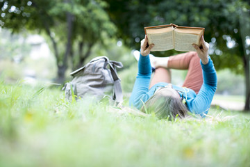 Young woman reading book at outdoor