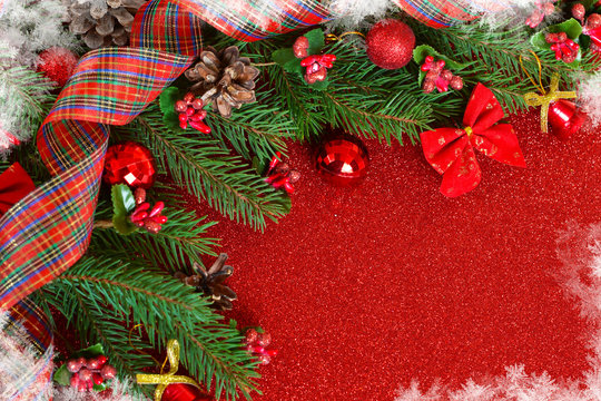 Happy New Year and Merry Christmas. New Year red background with spruce and decorations of balls and snowflakes.