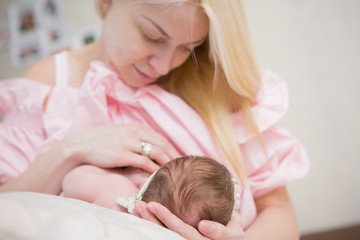Obraz na płótnie Canvas Happy baby lying next to the mother. Breastfeeding. Concept of motherhood.