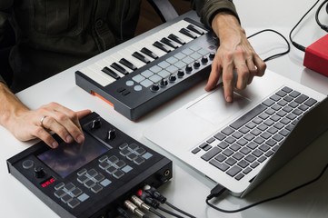 Producing electronic music on laptop with portable midi keyboard and electronic effect processors....