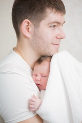 Newborn baby girl and her happy young father. Portrait of happy young family.