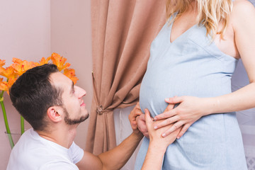 Pretty pregnant woman and her husband in studio