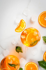Summer refreshing drink, lemonade, cocktail with orange and basil. On a white marble table, copy space top view