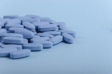 perspective view of blue medical tablets over a light blue background.