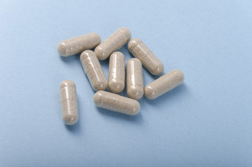 transparent medical capsule isolated over a light brown background.