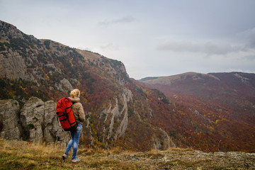 Girll at the top of a mountain looks at the valley