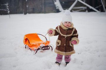 Fototapeta na wymiar cute girl with sled in snow