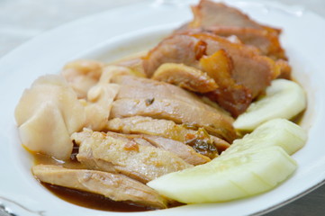 roasted duck and sweet barbecue pork in sauce on plate