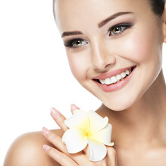 Beautiful smiling face of young woman with flower
