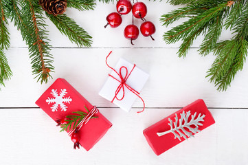 New Year's, Christmas theme. Green branches, gift boxes on white wooden background. Celebratory background.