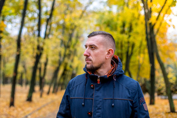 man walks in the autumn park. portrait of a man a look into the sky 