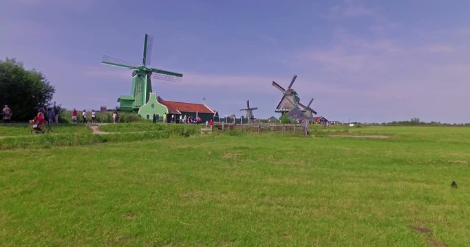 People visiting windmills and the farm village. Cinematic camera movement.