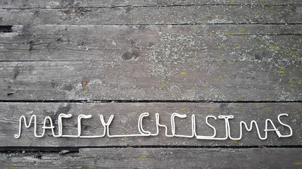 White lettering Merry Christmas on wooden background from old boards
