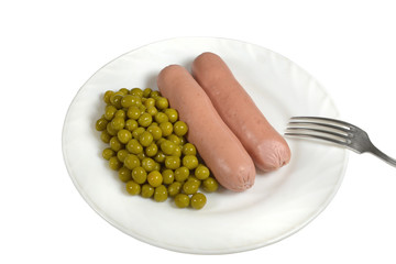 Two hot boiled sausages with canned green peas on a white plate are served for dinner. Closeup, isolated on white background