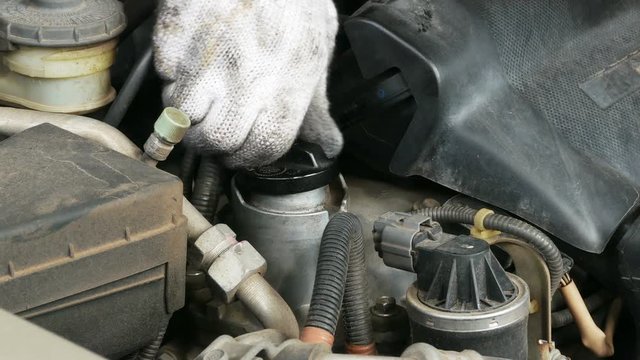 The repair shop is closing the lid after the oil is finished