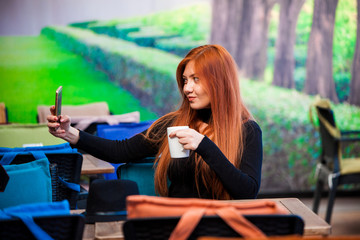 Fototapeta na wymiar Beautiful girl drinking coffee at the coffee shop