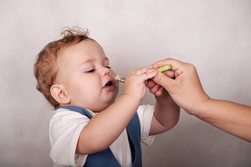 baby European appearance eats porridge from a spoon