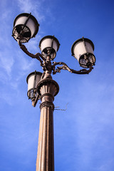 Fototapeta na wymiar Baroque street lamp over a blue sky