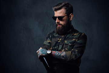 A man dressed in military shirt, drinks craft beer.