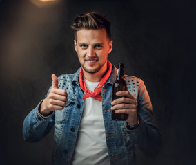 A man holds a bottle with craft beer.