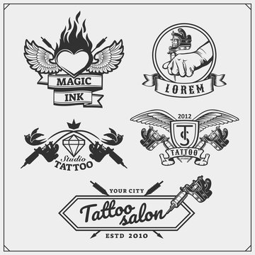 Vector set of tattoo salon labels, badges and design elements. Tattoo studio emblems with professional equipment.