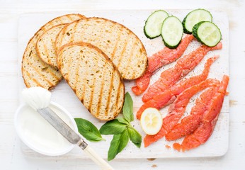 Ingredients for healthy sandwich. Grilled bread slices, smoked salmon, cottage cheese, cucumber nd...