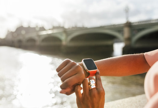 UK, London, close-up of woman using her smartwatch near Westminster Bridge