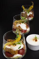 portion of gyros in a glass with lettuce, tomato and  meat covered with tzatziki