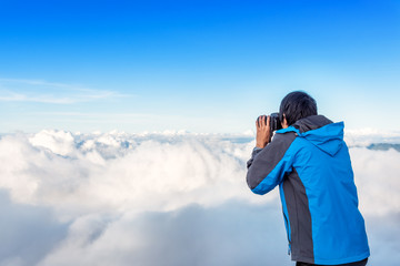 Nature photographer taking photo above the cloud and mountain. Mount Rinjani, Lombok, Indonesia.