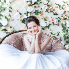 Obraz na płótnie Canvas Beautiful bride on a background of flowers, smiling