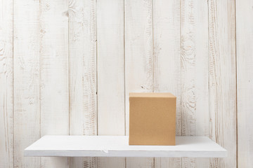 cardboard box on wooden shelf