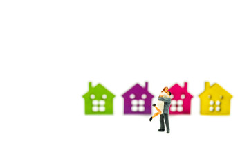 Miniature people, lovers hug on colorful house background using as relationship and family concept