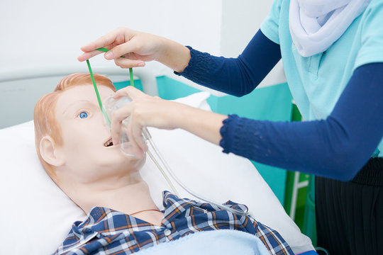 Nursing students are practicing how to provide oxygen administration to the patient by a doll of patient in the simulation of virtual presence in the hospital.