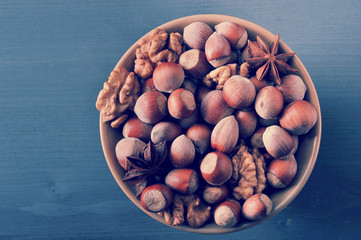Nuts in bowl - hazelnut in shell, peeled walnuts, anise