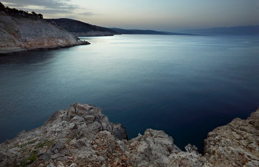 Fototapeta na wymiar sea with rocky shore in sunset light