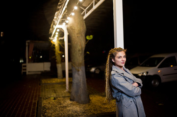 Fototapeta na wymiar Girl with dreadlocks walking at night street of city.