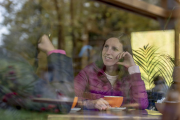 Woman seated at a table enjoying coffee with her friend