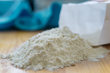 Close-up of a bunch of white wheat flour on a kitchen table. Shallow depth of focus.