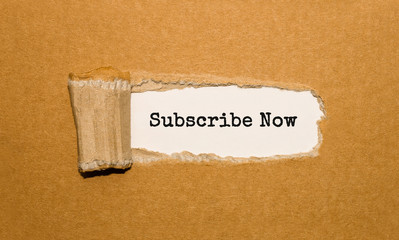 The text Subscribe Now appearing behind torn brown paper