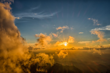 Beautiful mountain sky and clouds with golden light at sunset. subject is blurred.