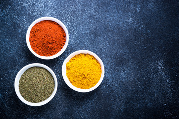 Various spices in a bowls on stone table.