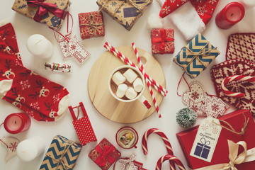 Christmas background with handmade presents wrapped in craft paper, cup of hot chocolate. Flat lay. Space for copy