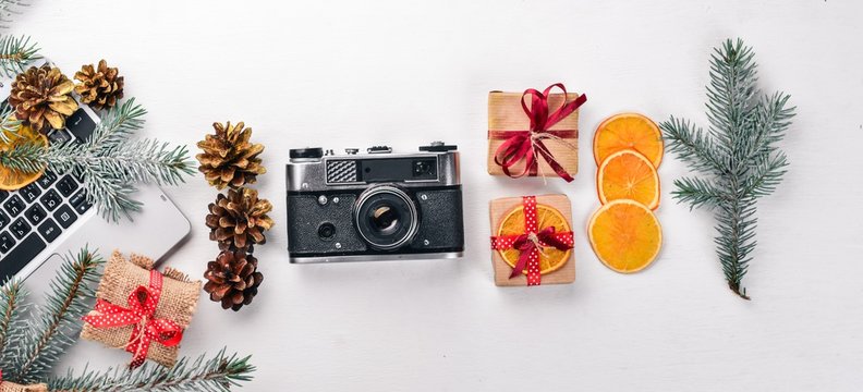 Camera Christmas wooden background. New Year's holiday. Christmas motive. On a wooden surface. Top view. Free space for your text.