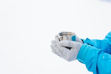 Woman holding stainless cup with hot tea