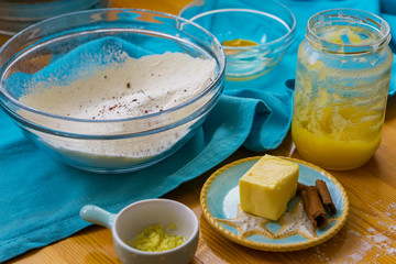 Close up of products for preparing Christmas cookies, cinnamon sticks, butter, ginger and flour. Shallow depth of focus.