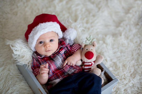 Christmas portrait of cute little newborn baby boy, dressed in christmas clothes