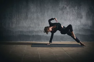  Beautiful sporty fit yogini woman practices yoga asana Wild Thing Pose in the dark hall © sandsun