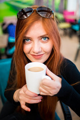 Beautiful girl drinking coffee at the coffee shop