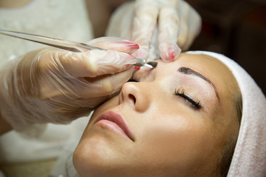Beautiful woman getting her eyebrows done at a beauty salon.